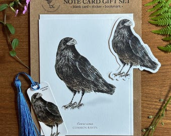 May include: A note card gift set featuring a detailed illustration of a common raven. The set includes a blank card, sticker, and bookmark. The raven is depicted in shades of black and brown, with the text "Common Raven" and "Corvus corax".