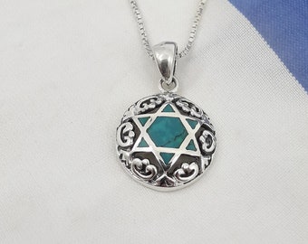 May include: A silver chain necklace with a pendant featuring a turquoise Star of David surrounded by an ornate silver design.