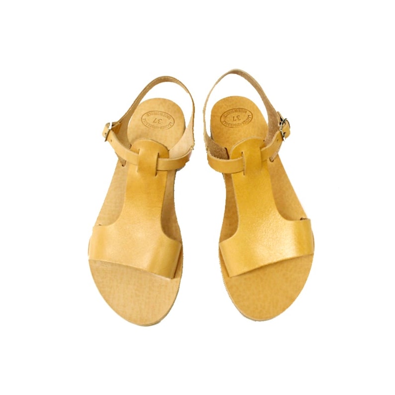 Peut inclure: Une paire de sandales en cuir couleur tan avec une bride en T et une fermeture &agrave; boucle.