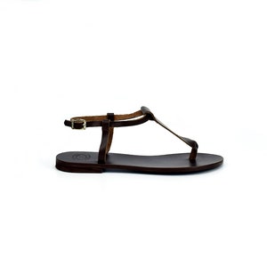 May include: Brown leather sandals with a T-strap and buckle closure.