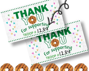 May include: Two white cards with a green border and colorful hearts printed on them. The cards say "Thank You for supporting Troop #1234" with a green cookie on the card.