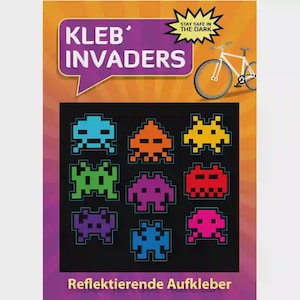 Puede incluir: Una lámina de pegatinas reflectantes con invasores alienígenas pixelados en varios colores. Las pegatinas están dispuestas sobre un fondo negro, con las palabras "Kleb' Invaders" y "Stay Safe in the Dark" en la parte superior. La parte inferior de la lámina dice "Reflektierende Aufkleber".