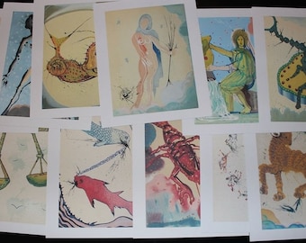 May include: A set of 12 zodiac sign prints featuring colorful illustrations of each sign. The prints are on white paper with a light beige background.