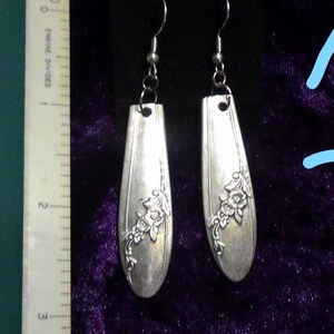 May include: A pair of silver earrings made from vintage silverware with floral designs. The earrings are approximately 2 inches long.