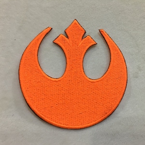 May include: Orange embroidered patch of the Rebel Alliance symbol from Star Wars.