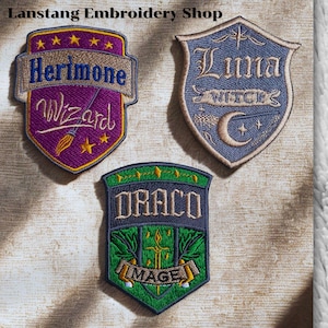 May include: Embroidered patches with shield designs. The patches feature the names "Herimone Wizard", "Luna Witches", and "Draco Mage". The patches are in purple, blue, and green with gold and yellow accents. The patches are from the "Langtang Embroidery Shop".