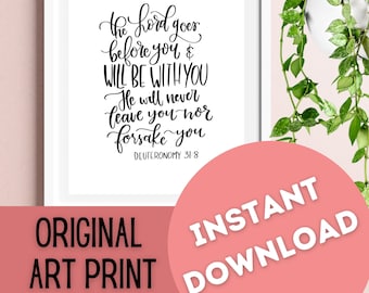 May include: A white framed art print with black calligraphy text that reads "The Lord goes before you & will be with you. He will never leave you nor forsake you. Deuteronomy 31:8". The print has a pink background with the words "Original Art Print" and "Instant Download" in black text.