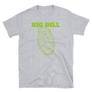 May include: A light gray t-shirt featuring the text "BIG DILL" in green above a green line drawing of a jar filled with pickles. The shirt is a short-sleeved crew neck.