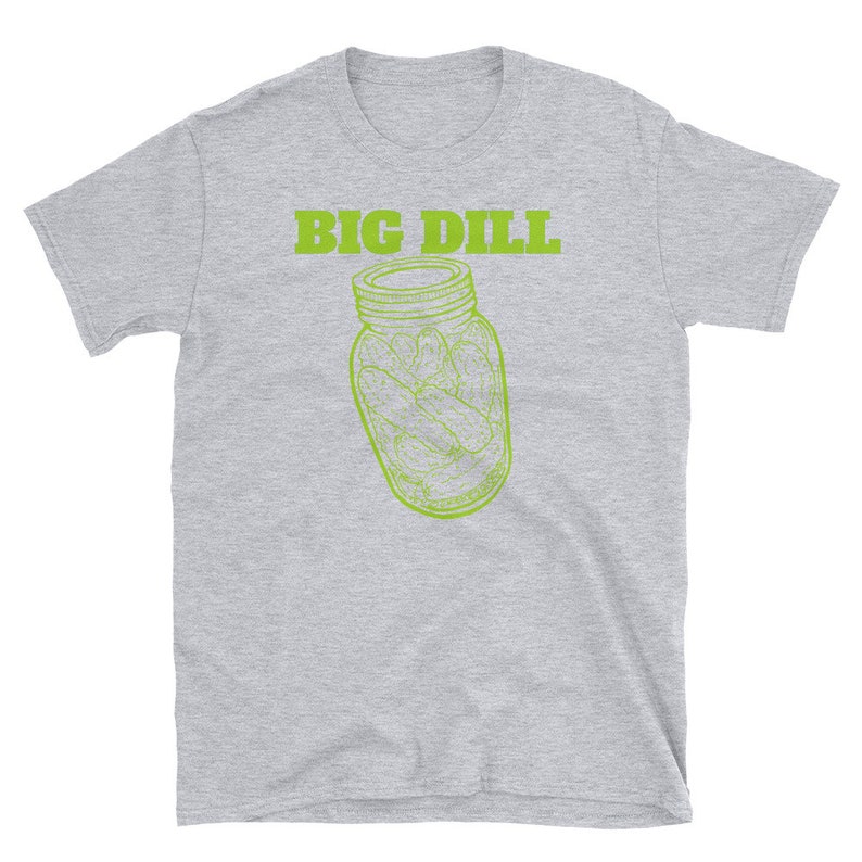 May include: A light gray t-shirt featuring the text "BIG DILL" in green above a green line drawing of a jar filled with pickles. The shirt is a short-sleeved crew neck.
