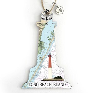 May include: A wooden lighthouse ornament with a nautical map design and a compass charm. The ornament features a red and white lighthouse with the text "LONG BEACH ISLAND" at the bottom.
