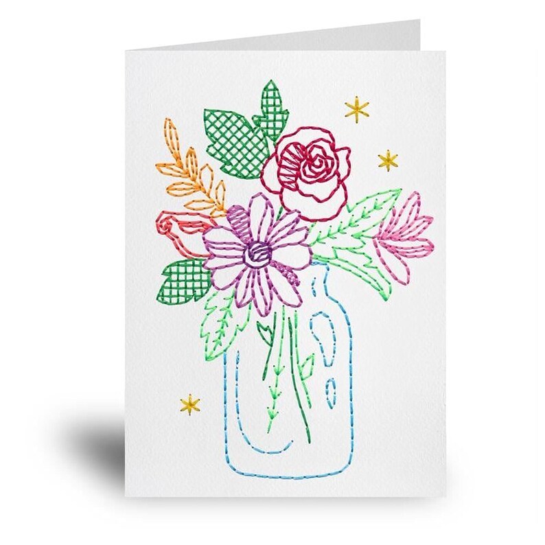 a card with a floral arrangement in a glass vase, which is embroidered with colorful flowers and leaves.