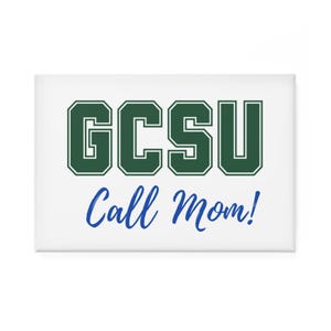 Puede incluir: Imán rectangular blanco con el texto "GCSU" en letras de bloque verde oscuro con un contorno blanco. Debajo, en escritura azul, se lee "Call Mom!". Un artículo de temática universitaria.