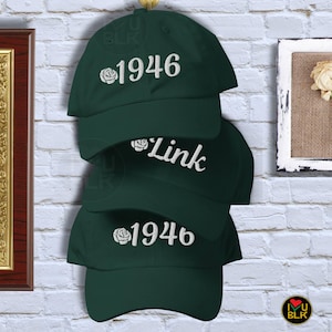 May include: Three dark green baseball caps with white embroidered roses and text. The top cap says "1946", the middle cap says "Link", and the bottom cap says "1946".