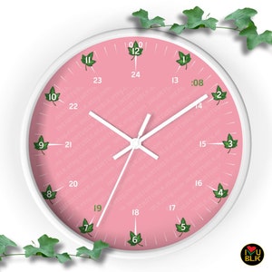 May include: A round wall clock with a white frame and a pink face. The clock face features green ivy leaf hour markers and white hands. The text "I HEART BLK" is visible at the bottom right. The clock is surrounded by green ivy.