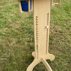May include: A wooden game with a numbered scale from 1 to 21. The game has a cup holder with a blue tumbler that says "Let the Weekend Be Gin". The game is on a green grassy surface and says "Top Dog" on the side.