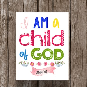 May include: A white printable sign with colorful text that reads "I AM a child of GOD" with a pink ribbon banner that says "JOHN 1:12" and floral accents.