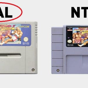 May include: Two Super Nintendo Entertainment System game cartridges for Street Fighter II: The World Warrior. The left cartridge is labeled "PAL Version" and the right cartridge is labeled "Super Nintendo Entertainment System".