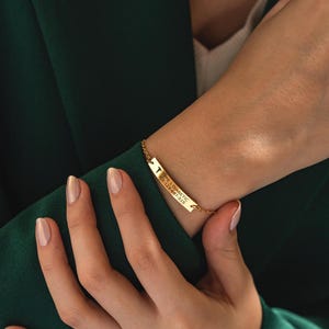 May include: Gold bracelet with a small cross charm and a rectangular tag that reads "TYPE 1 DIABETIC  TEL:123-456-7815".