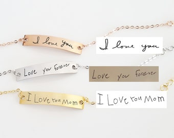 Puede incluir: Tres pulseras de barra metálica con cadenas delicadas. La barra superior de oro rosa está grabada con "I love you". La barra central de plata tiene "Love you forever". La barra inferior de oro tiene "I Love you Mom".