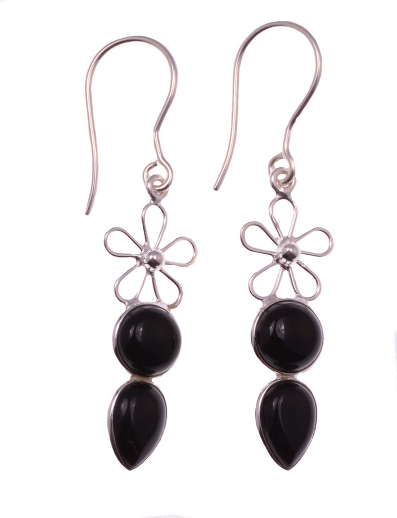 May include: A pair of silver dangle earrings with black gemstone drops and a flower design.