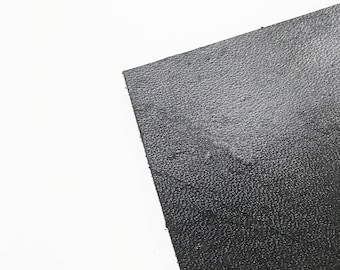 May include: A close-up of a black textured material. The material has a slightly rough surface.