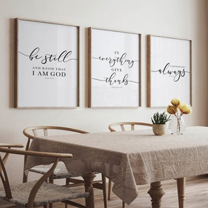 Puede incluir: Tres impresiones enmarcadas con citas inspiradoras en un ambiente de comedor. Las impresiones presentan las frases "Estate quieto y sabe que yo soy Dios", "En todo da gracias", y "Yo estoy contigo siempre".