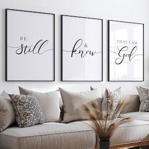Puede incluir: Tres impresiones enmarcadas en negro con fondos blancos y caligrafía negra. Las impresiones dicen "Be still", "& know" y "That I am God".
