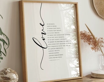 May include: A framed print with the word "love" in elegant cursive script. The print features a list of qualities of love, set against a white background. The frame is a light brown color.