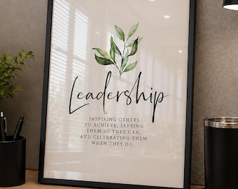 Peut inclure: Une affiche encadrée avec le mot Leadership en écriture noire, accompagnée d'une illustration de feuilles vertes et du texte : Inspiring others to achieve, serving them so they can, and celebrating them when they do. Le cadre est noir.