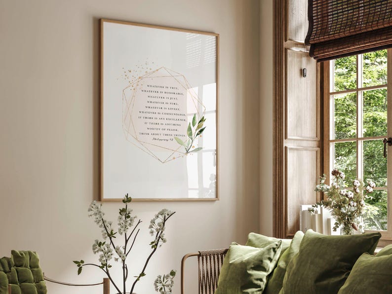 May include: A framed print with a white background and a gold geometric frame. The print features a quote from Philippians 4:8, "Whatever is true, whatever is noble, whatever is right, whatever is pure, whatever is lovely, whatever is admirable&mdash;if anything is excellent or praiseworthy&mdash;think about such things." The quote is surrounded by a watercolor illustration of green leaves.