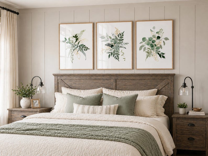 Puede incluir: Tres estampados bot&aacute;nicos enmarcados con follaje verde y dorado cuelgan sobre una cama con cabecero de madera. La cama est&aacute; hecha con ropa de cama color crema y acentuada con almohadas verdes y una colcha a juego. Dos mesitas de noche con l&aacute;mparas flanquean la cama.