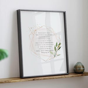 May include: A framed print with a white background and a gold geometric design. The print features a quote from Philippians 4:8, "Whatever is true, whatever is honorable, whatever is just, whatever is pure, whatever is lovely, whatever is commendable, if there is any excellence, if there is anything worthy of praise, think about these things."