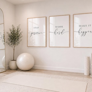 May include: A home gym interior with motivational wall art. Three framed prints with the phrases "Stay Positive", "Work Hard", and "Make It Happen" are displayed. A large mirror, exercise ball, and weights are also visible.