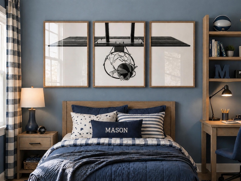 May include: A bedroom featuring a bed with a navy blue quilt, a rectangular pillow with the name MASON embroidered in white, and a set of three framed wall art prints depicting a basketball hoop and ball in a black and white graphic style.
