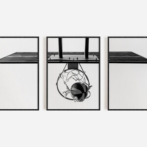 May include: A triptych of three black and white framed prints. The outer two prints show a side view of a basketball backboard. The center print shows a basketball passing through a hoop with a net, attached to a backboard with two vertical poles.