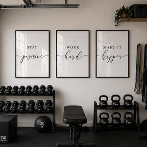 May include: A home gym setup with three framed motivational prints that read "Stay Positive", "Work Hard", and "Make it Happen". The room includes dumbbells, kettlebells, a weight bench, and a plyometric box that is 24 inches.