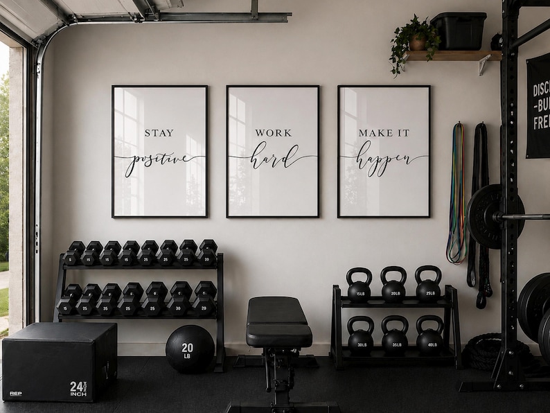 May include: A home gym setup with three framed motivational prints that read "Stay Positive", "Work Hard", and "Make it Happen". The room includes dumbbells, kettlebells, a weight bench, and a plyometric box that is 24 inches.