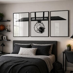 May include: A triptych wall art set featuring a black and white photograph of a basketball hoop and backboard. The three framed prints are displayed horizontally above a bed, showcasing a minimalist aesthetic with high-contrast monochrome tones.