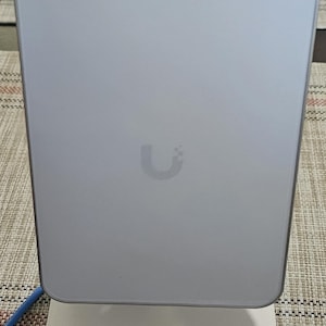 May include: A white wireless router with a U logo on the front. The router is sitting on a white base.