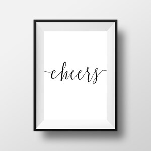 May include: A framed print with the word "cheers" in elegant, cursive black script centered on a white background. The frame is a simple, black rectangle, creating a clean and modern aesthetic. Perfect for home decor.