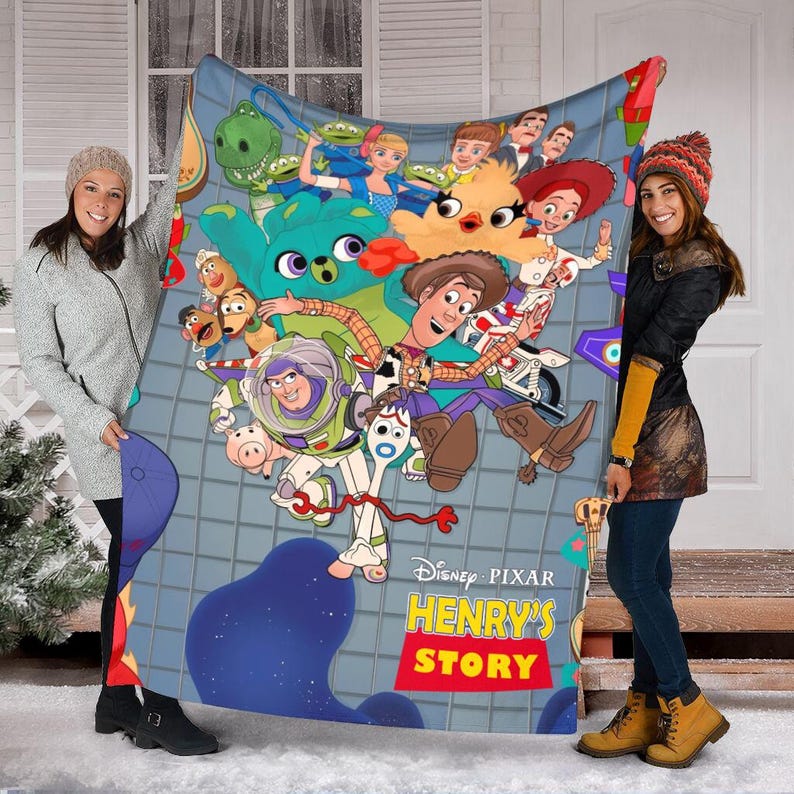 K&ouml;nnte beinhalten: Eine bunte Fleece-Decke mit Figuren aus dem Disney Pixar Film Toy Story. Die Decke zeigt Woody, Buzz Lightyear, Jessie und andere Figuren aus dem Film. Die Decke ist blau, gr&uuml;n, rot, gelb und orange. Der Text "Disney Pixar Henry's Story" ist auf der Decke aufgedruckt.