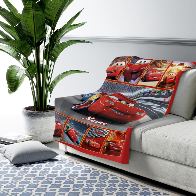 Puede incluir: Una manta de forro polar suave con un collage de Lightning McQueen de la franquicia Cars. El dise&ntilde;o incluye varias escenas de carreras, una gran imagen central del coche de carreras rojo y la palabra Name impresa en letra cursiva blanca.