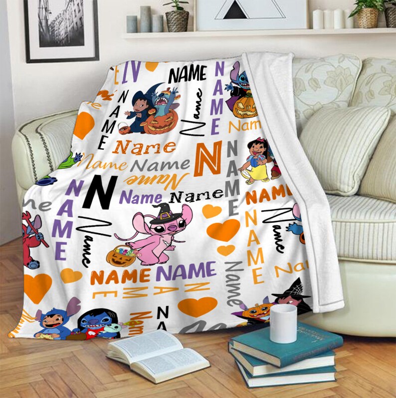 Może przedstawiać: Biały koc z polaru z powtarzającym się wzorem o tematyce Halloween, przedstawiającym postacie Stitcha i Angel w kostiumach, pomarańczowe serca oraz słowo Name wydrukowane r&oacute;żnymi czcionkami, rozmiarami i kolorami, w tym czarnym, pomarańczowym, fioletowym i szarym.