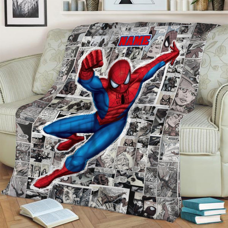 May include: A soft throw blanket featuring a large, colorful illustration of Spider-Man in a dynamic leaping pose over a black and white comic book panel background. The blanket includes a prominent red and blue text box labeled NAME.