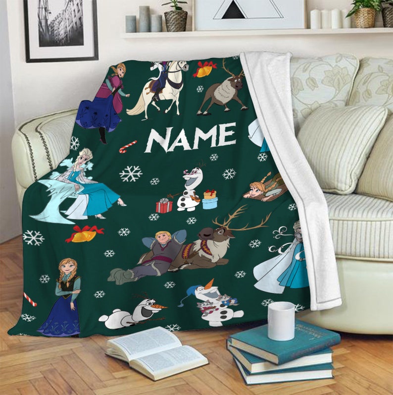 May include: A dark green fleece throw blanket featuring a repeating pattern of characters from Frozen, including Elsa, Anna, Olaf, Kristoff, and Sven. The design includes white snowflakes, candy canes, bells, and the word NAME in white text.