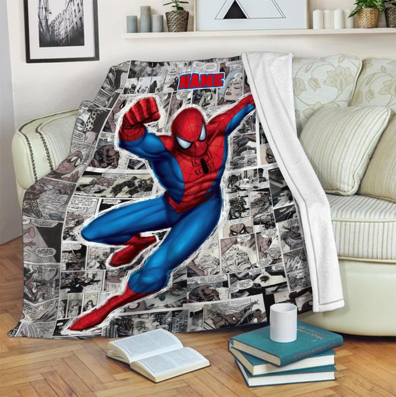 May include: A soft throw blanket featuring a large, colorful illustration of Spider-Man in a dynamic pose over a black and white comic book panel background. The blanket includes a red text box at the top with the word NAME in bold blue letters.