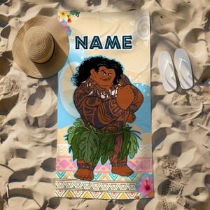 May include: A rectangular beach towel featuring a graphic illustration of a muscular character with dark curly hair, tribal tattoos, and a green leaf skirt. The word NAME is printed in dark blue at the top, with colorful geometric patterns and flowers.