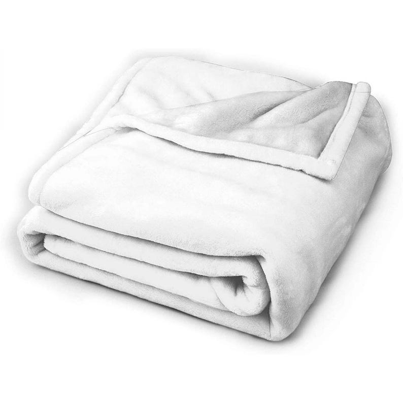 K&ouml;nnte beinhalten: Eine gefaltete, wei&szlig;e Pl&uuml;schdecke. Die Decke besteht aus einem weichen, flauschigen Material und hat ein glattes, sauberes Aussehen. Die Kanten sind sauber verarbeitet und die Decke ist zu einem kompakten Quadrat gefaltet.