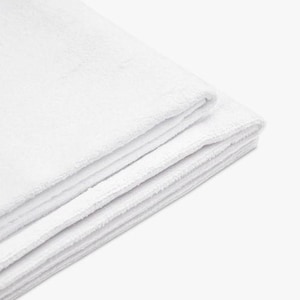 May include: A stack of folded, white, fluffy towels. The towels are made of a soft, absorbent material, and are neatly stacked on top of each other. The edges of the towels are visible, showing their thickness and texture.