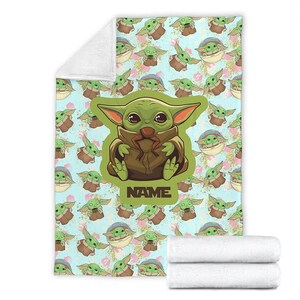 Może przedstawiać: Zielona i brązowa postać z kresk&oacute;wki z dużymi oczami i uroczym wyrazem twarzy. Postać siedzi na niebieskim tle z wzorem mniejszych wersji postaci. Tekst "NAME" jest wydrukowany pod postacią.